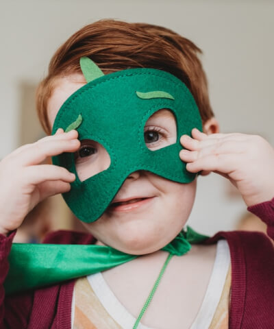 Kid using a dinosaur mask