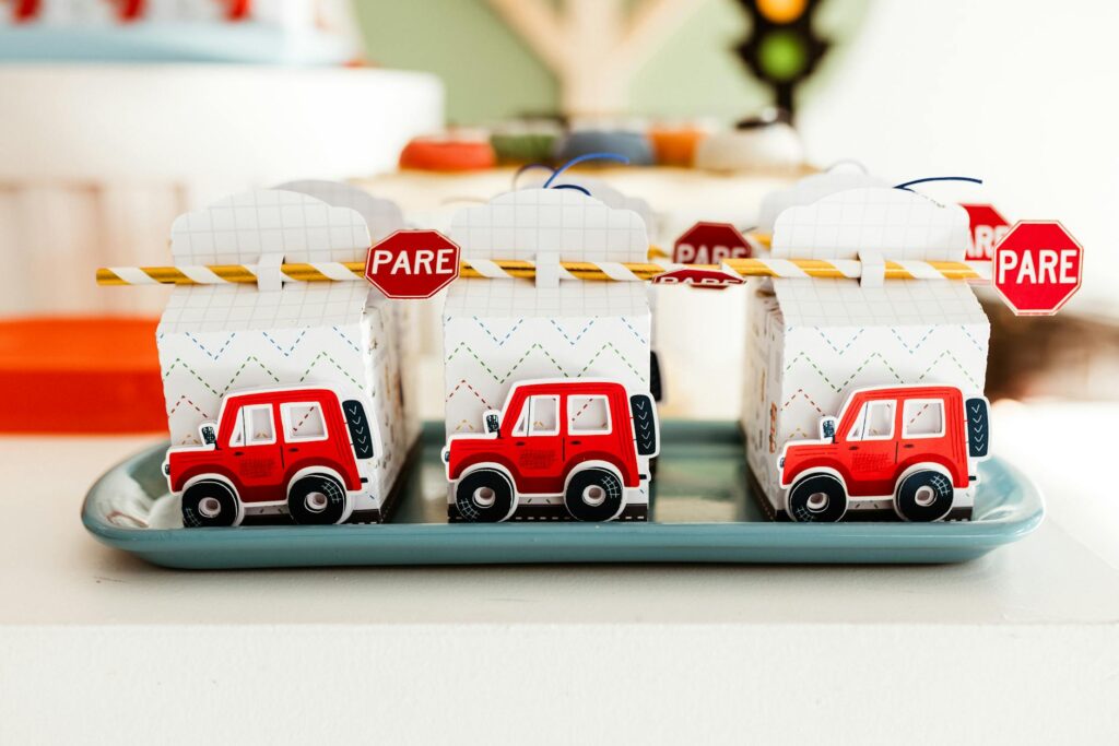 Vibrant party favor boxes with toy cars and 'PARE' signs, ideal for children's parties.